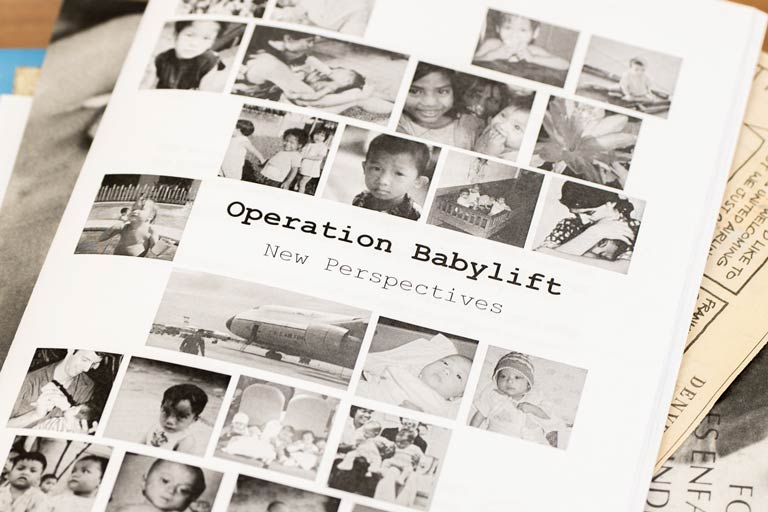 Cover of a book with many photos of infants during the Vietnam war: Operation Babylift New Perspectives
