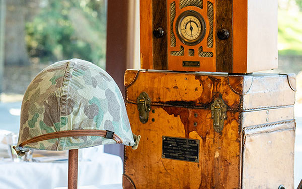 a collection of war memorabilia, including a camouflage helmet and an old radio